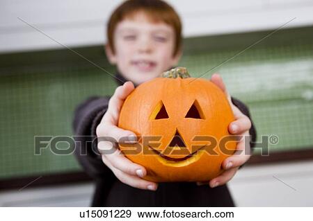 Stock Photo - Boy holding a Jack'o Lantern for Halloween . Fotosearch