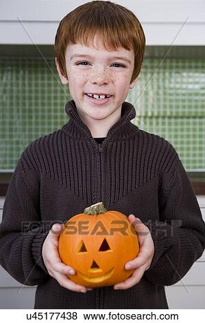 Boy holding a Jack'o Lantern for Halloween View Large Photo Image Stock Photo - Boy holding a Jack'o Lantern for Halloween . Fotosearch