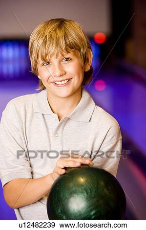 Boy in a bowling alley holding a green bowling ball View Large Photo Image Stock Photo - Boy in a bowling alley holding a green bowling ball. Fotosearch