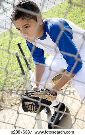 Stock Photo - Boy in baseball gear sitting on a bench. Fotosearch