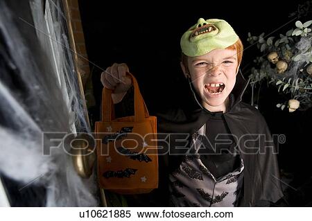 Boy in costume at a Hallowe'en party, holding an orange party bag View Large Photo Image Stock Photography - Boy in costume at a Hallowe'en party, holding an orange party bag. Fotosearch
