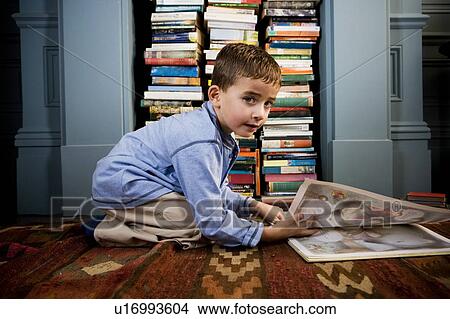 boy looking at picture book on the floor View Large Photo Image Picture - boy looking at picture book on the floor. Fotosearch