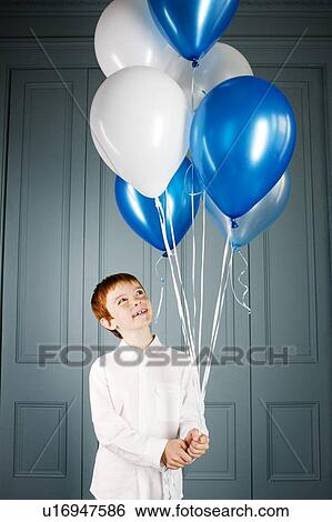 boy looking up at balloons he's holding View Large Photo Image Stock Photograph - boy looking up at balloons he's holding. Fotosearch