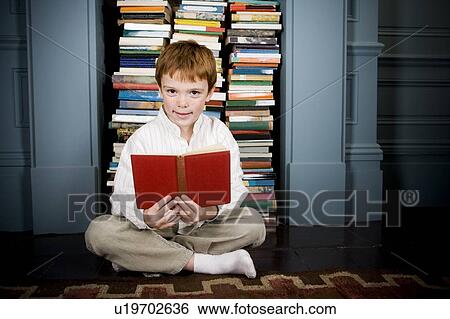 Stock Photograph - boy reading book sitting on the floor. Fotosearch