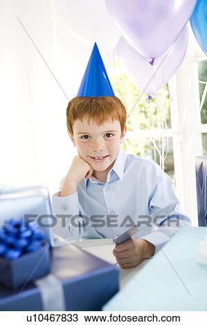 Boy with birthday presents at party View Large Photo Image Stock Image - Boy with birthday presents at party. Fotosearch