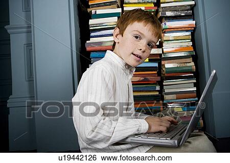 Stock Photograph - boy with laptop looking at camera. Fotosearch