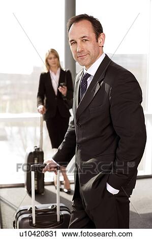 Businessman and businesswoman traveling, waiting in airport or station View Large Photo Image Stock Image - Businessman and businesswoman traveling, waiting in airport or station. Fotosearch