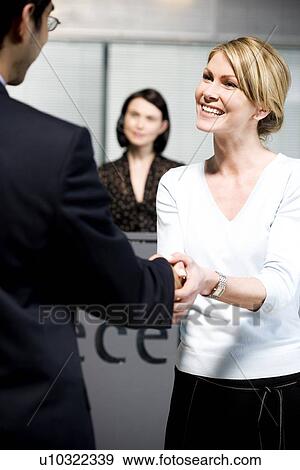 Stock Photo - Businessman being greeted at office reception. Fotosearch