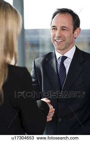 Businessman shaking hands with female client or colleague View Large Photo Image Stock Image - Businessman shaking hands with female client or colleague. Fotosearch