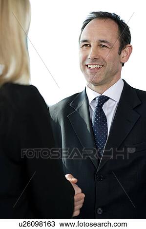 Businessman shaking hands with female client or colleague View Large Photo Image Stock Image - Businessman shaking hands with female client or colleague. Fotosearch