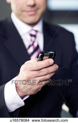 Picture - Businessman using a mobile phone. Fotosearch