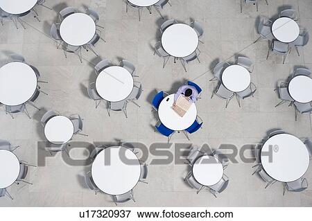 Businessman working on laptop at table of office canteen View Large Photo Image Stock Photo - Businessman working on laptop at table of office canteen. Fotosearch