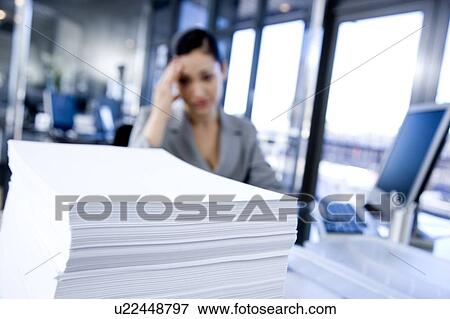 Stock Photo - Businesswoman looking stressed in a contemporary office. Fotosearch
