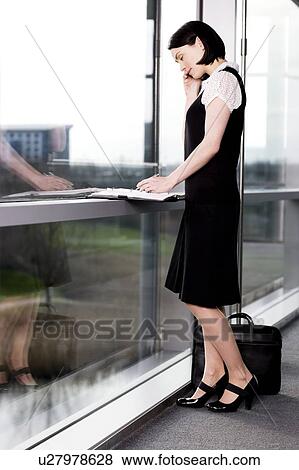 Stock Photo - Businesswoman or secretary making an appointment in a diary. Fotosearch