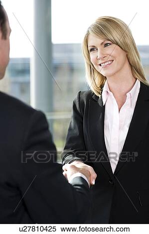 Businesswoman shaking hands with male client or colleague View Large Photo Image Stock Photography - Businesswoman shaking hands with male client or colleague. Fotosearch