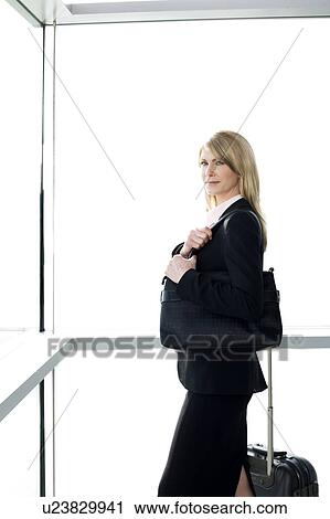 Stock Image - Businesswoman traveling, waiting at airport or station. Fotosearch