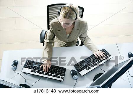 Businesswoman with two computers, aerial view on a trading floor View Large Photo Image Stock Photo - Businesswoman with two computers, aerial view on a trading floor. Fotosearch