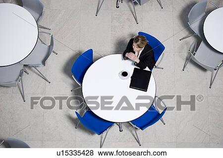 Stock Photo - Businesswoman working on laptop at table of office canteen. Fotosearch
