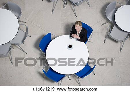 Stock Photo - Businesswoman working on laptop at table of office canteen. Fotosearch