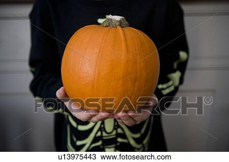 Child holding an orange Hallowe'en pumpkin View Large Photo Image Stock Image - Child holding an orange Hallowe'en pumpkin. Fotosearch