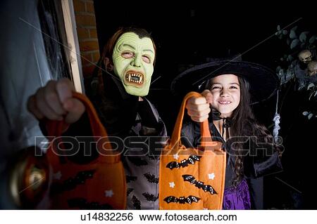 Children in costumes at a Hallowe'en party, holding orange party bags View Large Photo Image Stock Photograph - Children in costumes at a Hallowe'en party, holding orange party bags. Fotosearch