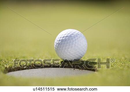 Close-up of a golf ball on the edge of a hole View Large Photo Image Stock Photography - Close-up of a golf ball on the edge of a hole. Fotosearch