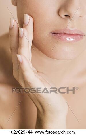 Close-up of woman touching her cheek View Large Photo Image Picture - Close-up of woman touching her cheek. Fotosearch