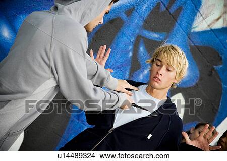 Picture - Confrontation between two young men in front of a graffiti covered wall . Fotosearch