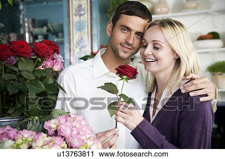 Couple choosing flowers in a florist's shop, red roses View Large Photo Image Stock Image - Couple choosing flowers in a florist's shop, red roses. Fotosearch