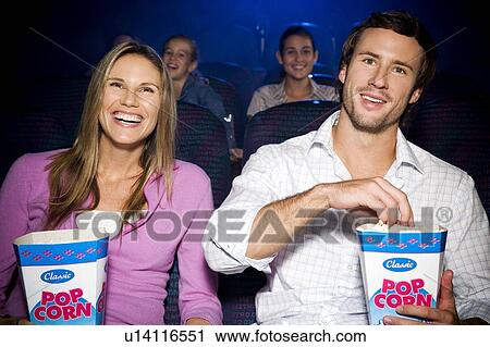 Couple enjoying a film at the cinema View Large Photo Image Stock Image - Couple enjoying a film at the cinema. Fotosearch