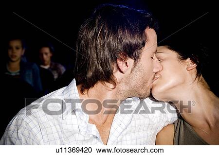 Stock Image - Couple kissing at the cinema. Fotosearch