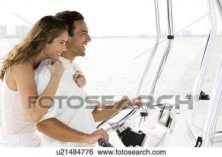 Couple on board a luxury yacht, man steering View Large Photo Image Stock Photograph - Couple on board a luxury yacht, man steering. Fotosearch
