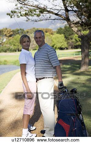 Stock Photograph - Couple walking on a golf course. Fotosearch