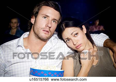 Stock Photograph - Couple watching a sad film at the cinema. Fotosearch