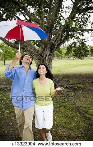 couple with umbrella walking in the park View Large Photo Image Picture - couple with umbrella walking in the park. Fotosearch