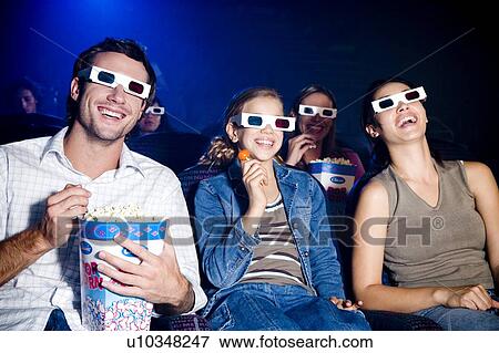 Family at the cinema watching a film through 3-D glasses View Large Photo Image Stock Photo - Family at the cinema watching a film through 3-D glasses. Fotosearch