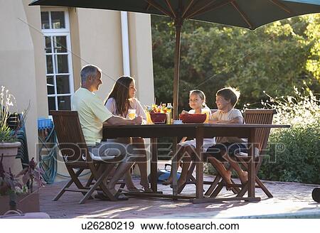 Stock Photo - Family eating in the garden. Fotosearch