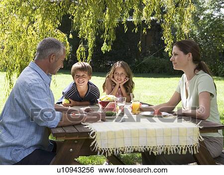 Stock Photograph - Family having lunch in the garden. Fotosearch