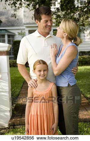Family standing on the garden path outside their new home View Large Photo Image Stock Photograph - Family standing on the garden path outside their new home. Fotosearch