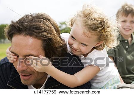 Stock Photo - Father and children having fun in the park. Fotosearch