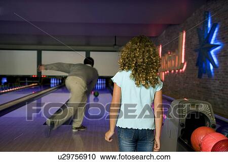 Stock Image - Father and daughter bowling. Fotosearch
