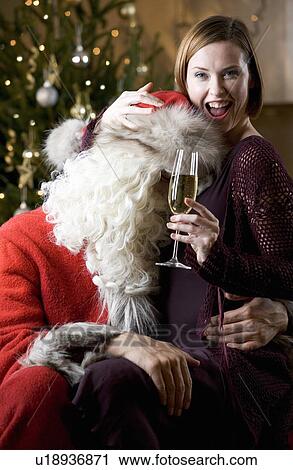 Stock Image - Father christmas / santa Claus and a woman drinking champagne. Fotosearch