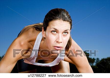 Stock Photo - Female athlete in the starting blocks. Fotosearch