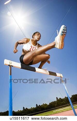 Female hurdler in action View Large Photo Image Stock Photo - Female hurdler in action. Fotosearch