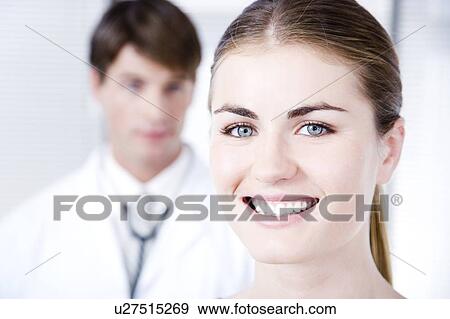 Female with male doctor out of focus in background View Large Photo Image Stock Photo - Female with male doctor out of focus in background. Fotosearch