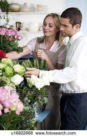 Stock Photo - Florist helping male customer to choose some flowers. Fotosearch