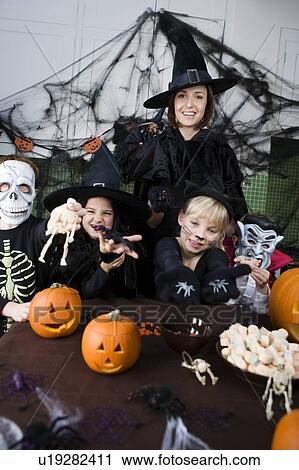 Stock Image - Four friends and a mother at a Halloween party . Fotosearch