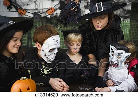 Four friends and a mother at a Halloween party View Large Photo Image Stock Photo - Four friends and a mother at a Halloween party . Fotosearch