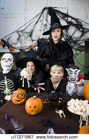Stock Photo - Four friends and a mother at a Halloween party . Fotosearch