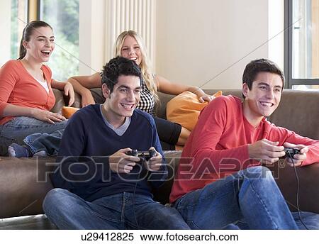 Four teenage friends playing a computer game View Large Photo Image Stock Photography - Four teenage friends playing a computer game. Fotosearch